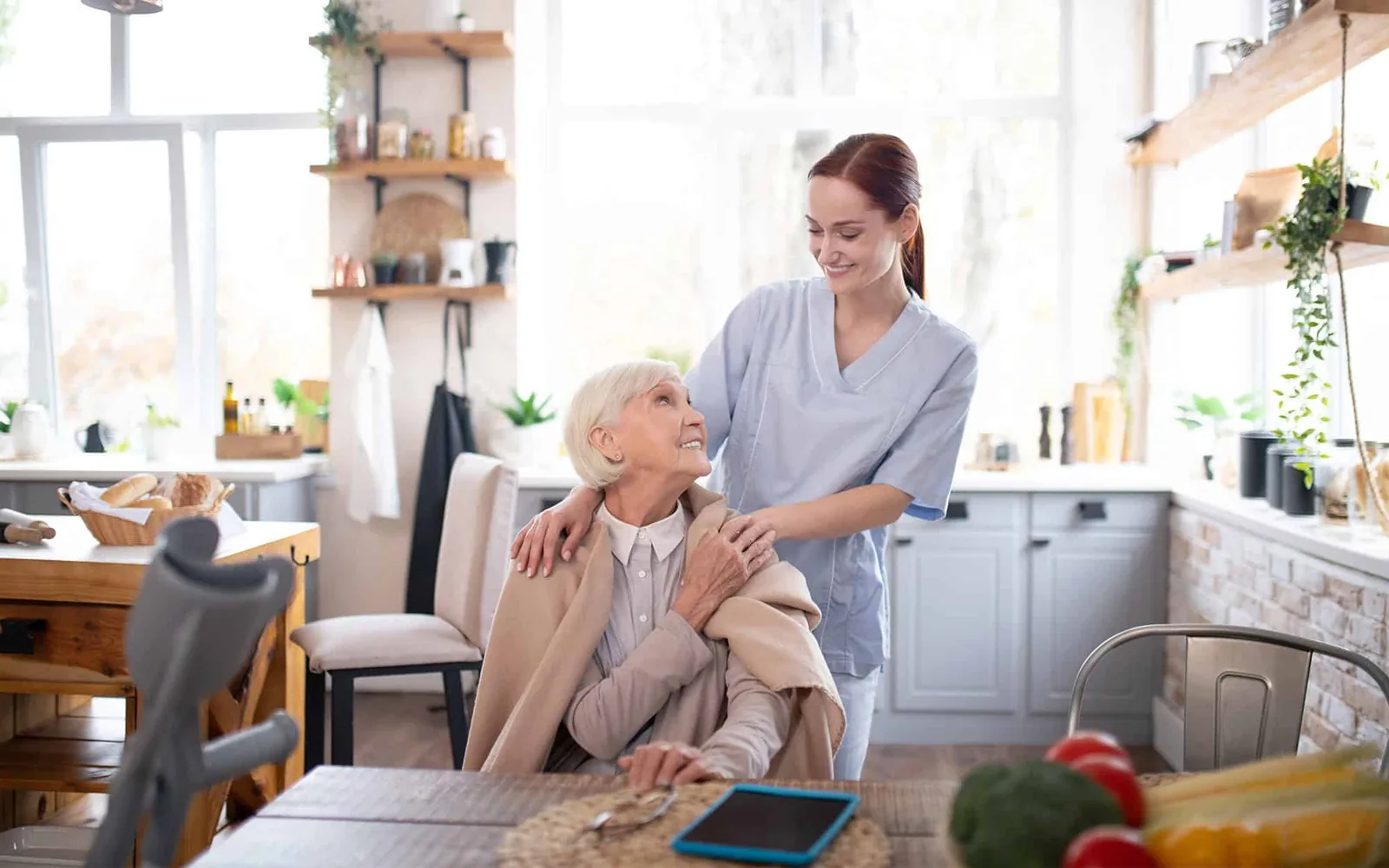 A caregiver offering reassuring support to an older woman at home